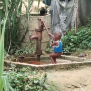 A young Rohingya boy challenged by the water pump
