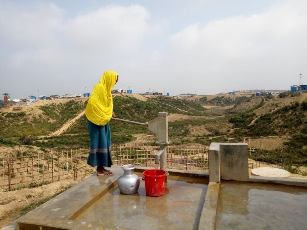 A Rohingya woman is getting fresh water from the pump